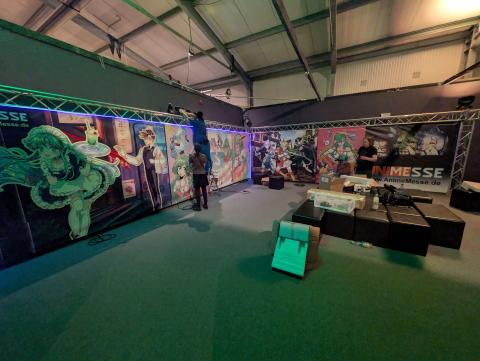 Der Gamesroom während des Aufbaus. Zwei Personen arbeiten an den Trassen.